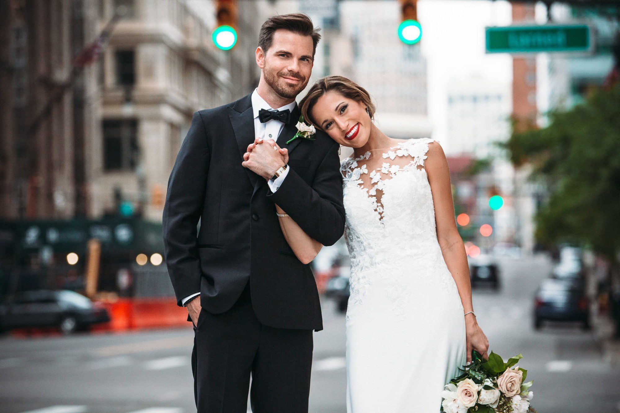 bride and groom holding hands in the middle of the street