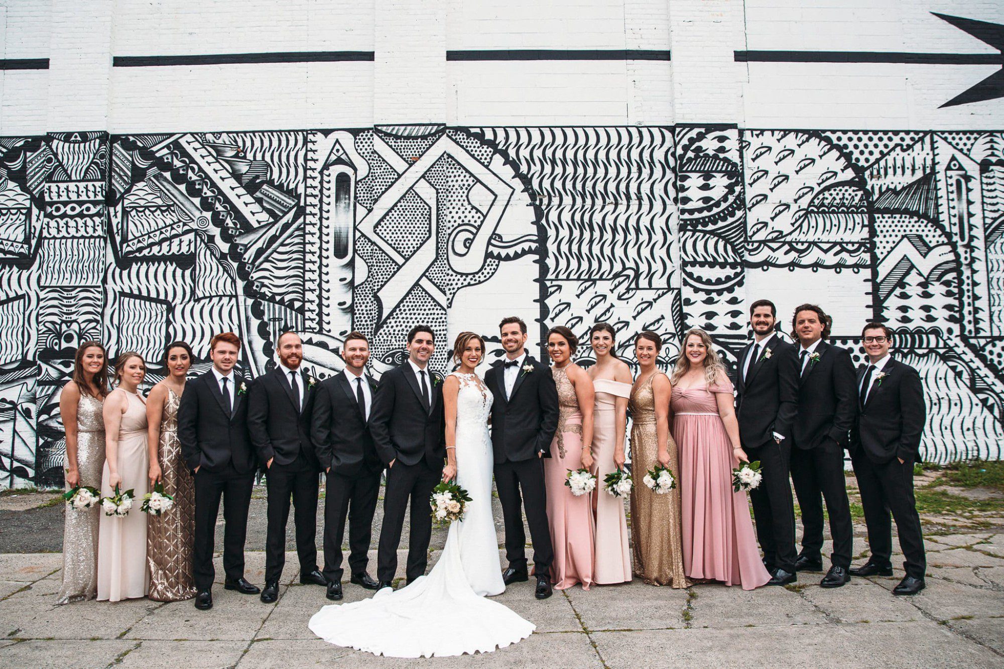 wedding party photo in front of mural