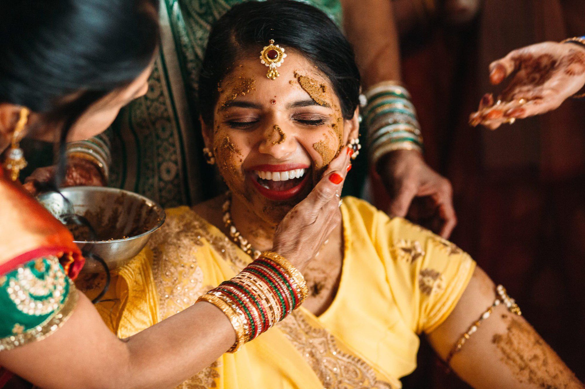 Indian bride laughing during Haldi ceremony