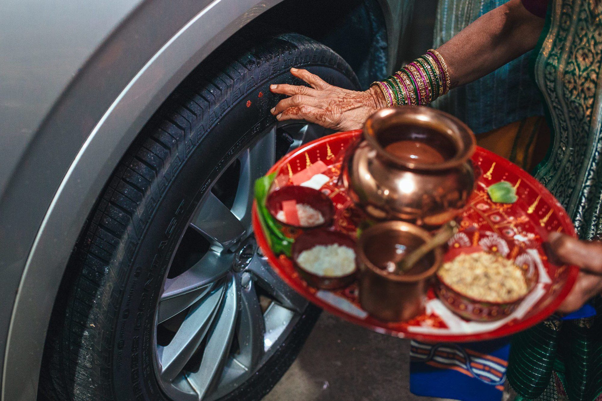 Woman putting red powder on tire during Vidaai