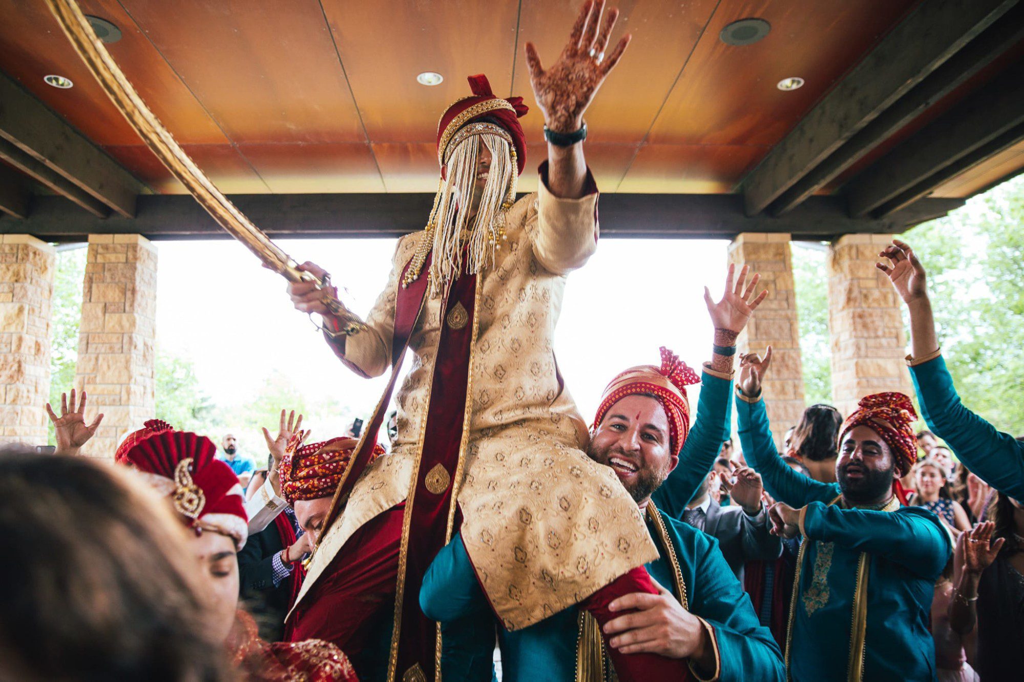 Indian groom on the shoulders of groomsman