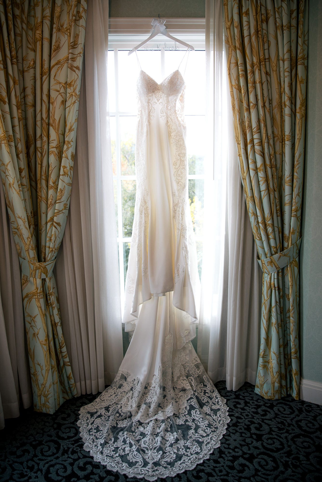 Wedding dress hanging up in front of window