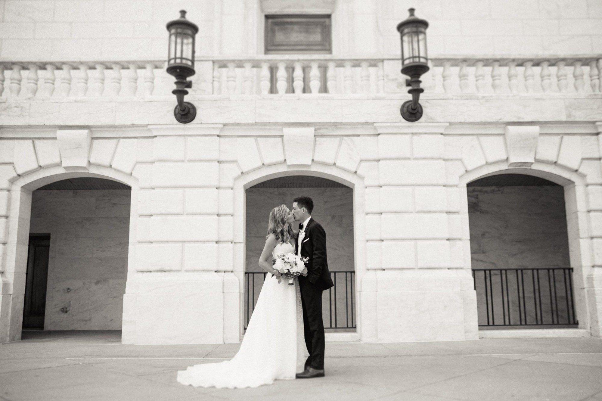 Bride and groom kissing outside of Detroit Institute of Arts