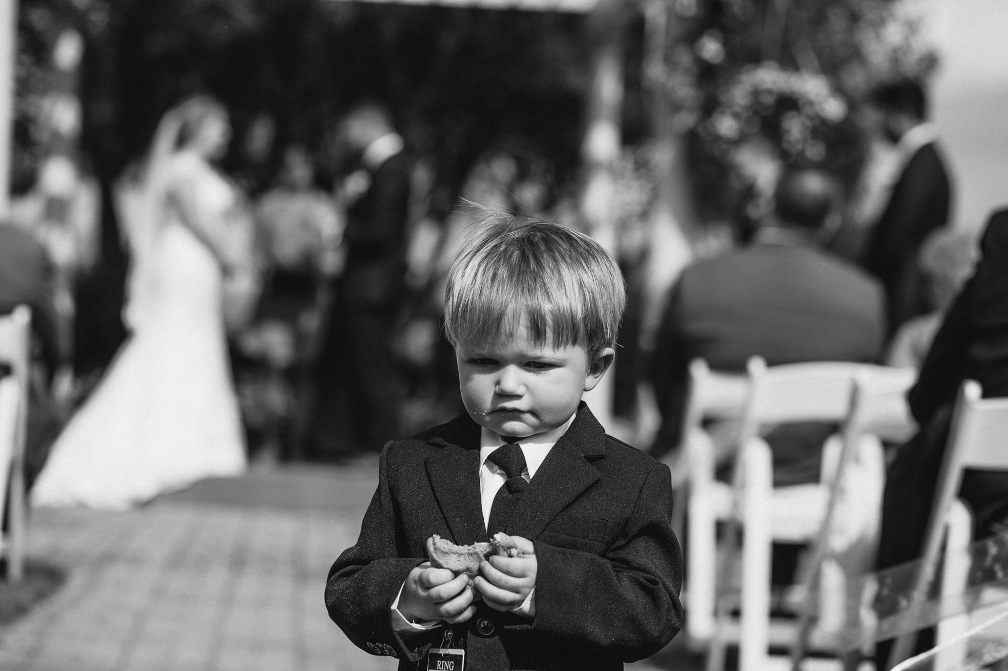 ring bearer eating cookie during ceremony