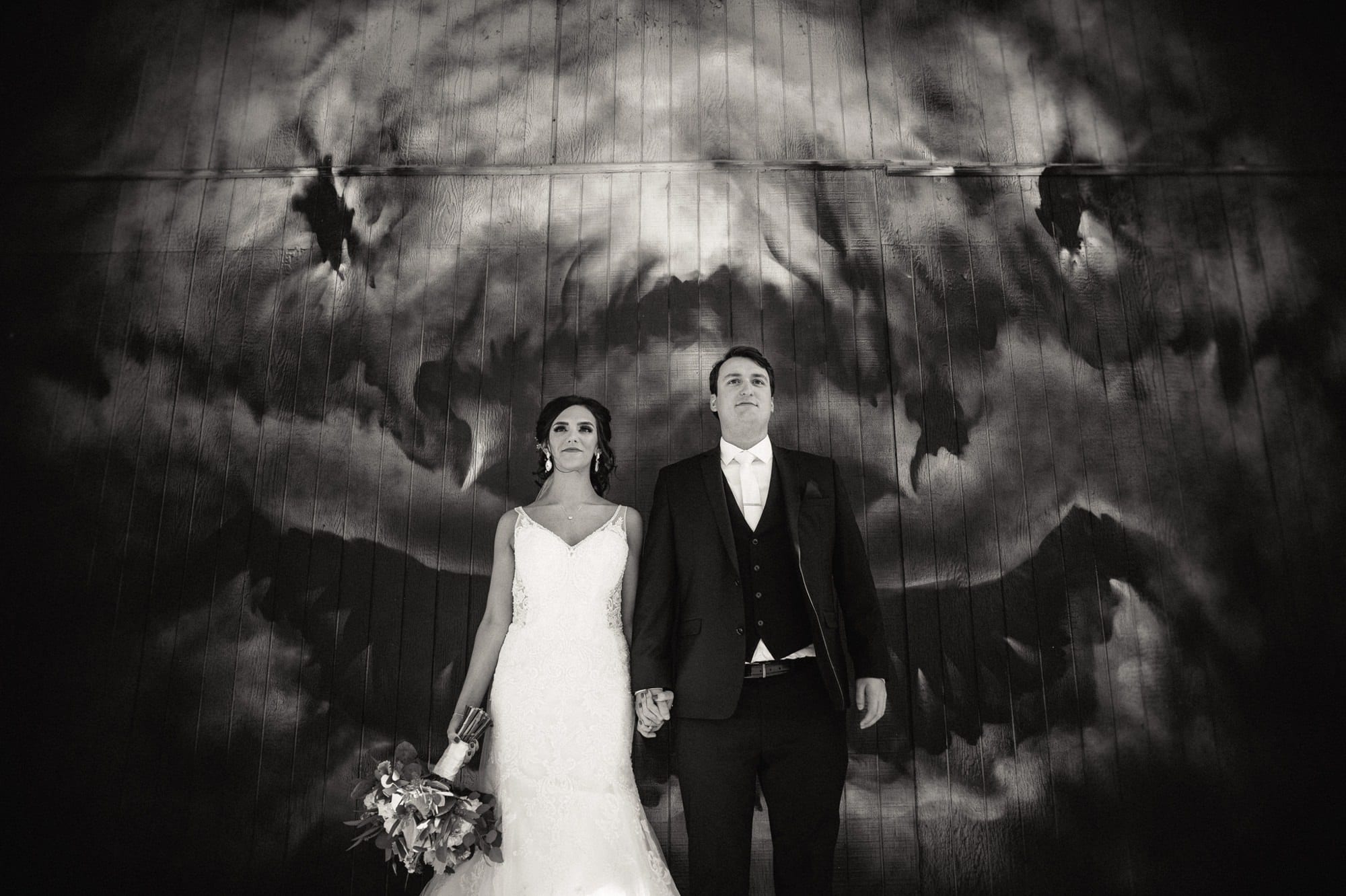 bride and groom in front of shark mural