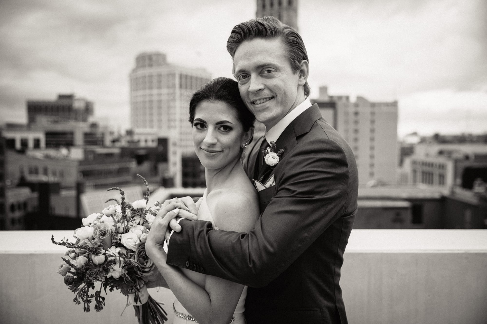 wedding photo of bride and groom with Detroit skyline in background