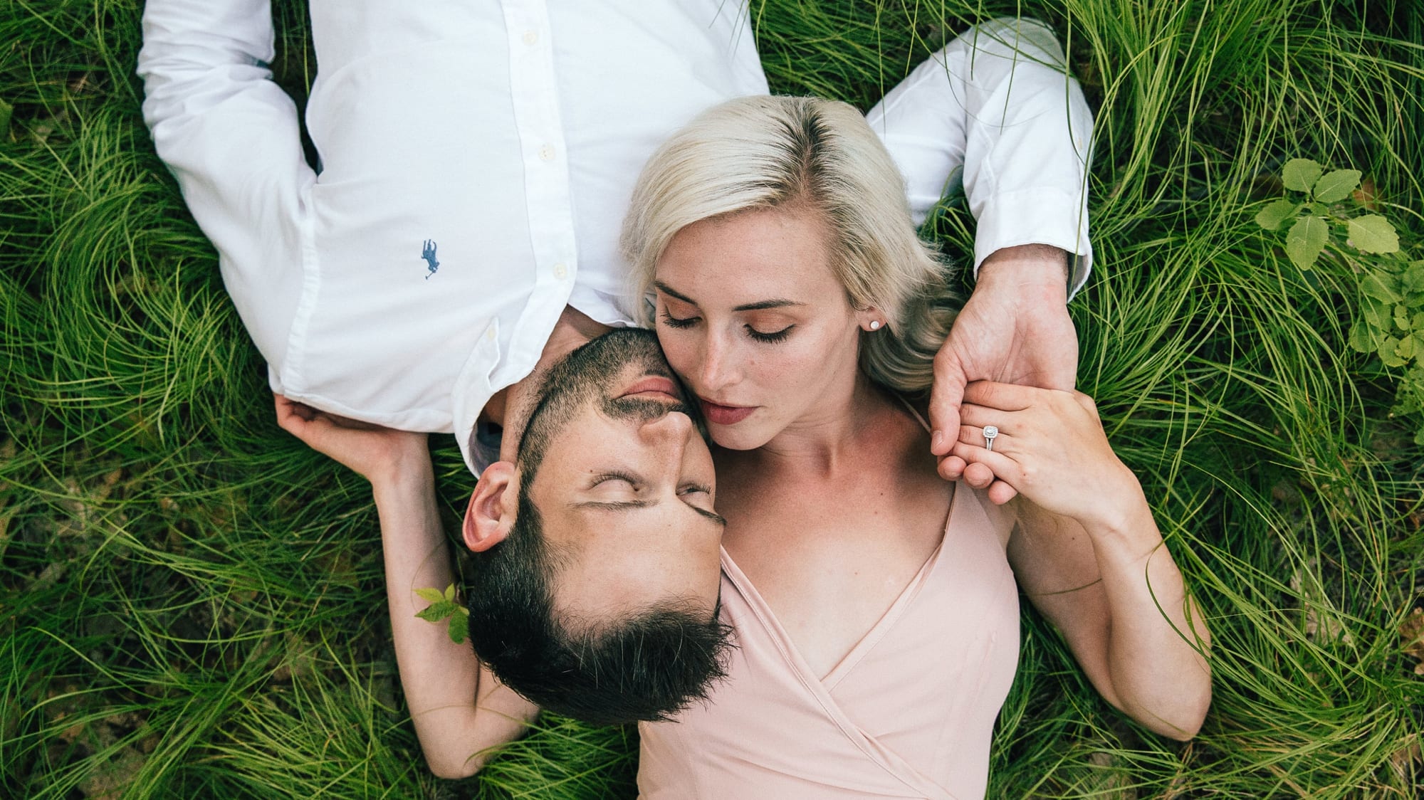 engagement photo of couple laying in the grass