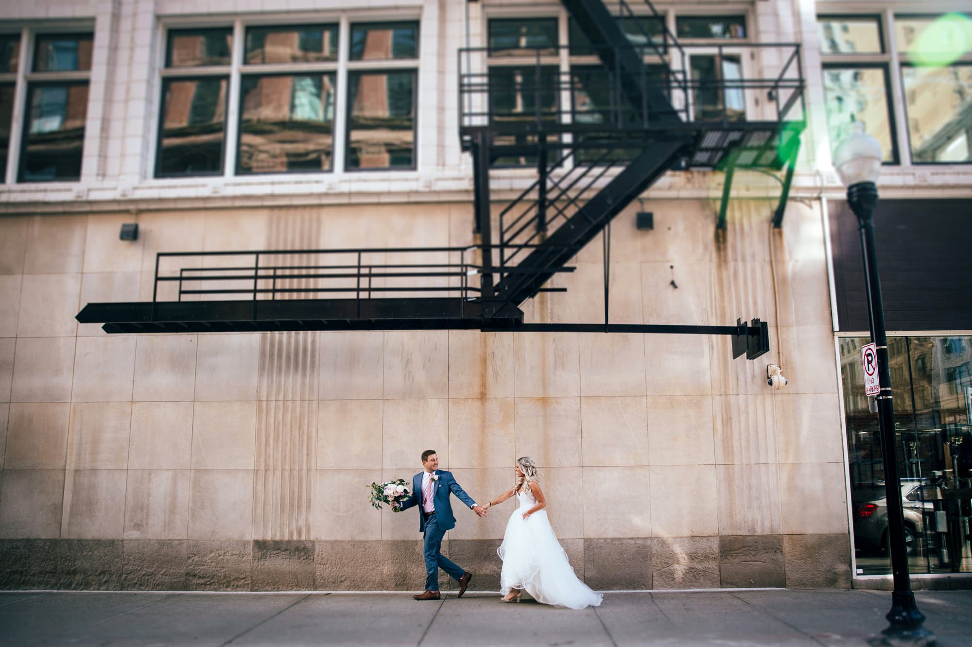 bride and groom running Downtown Detroit