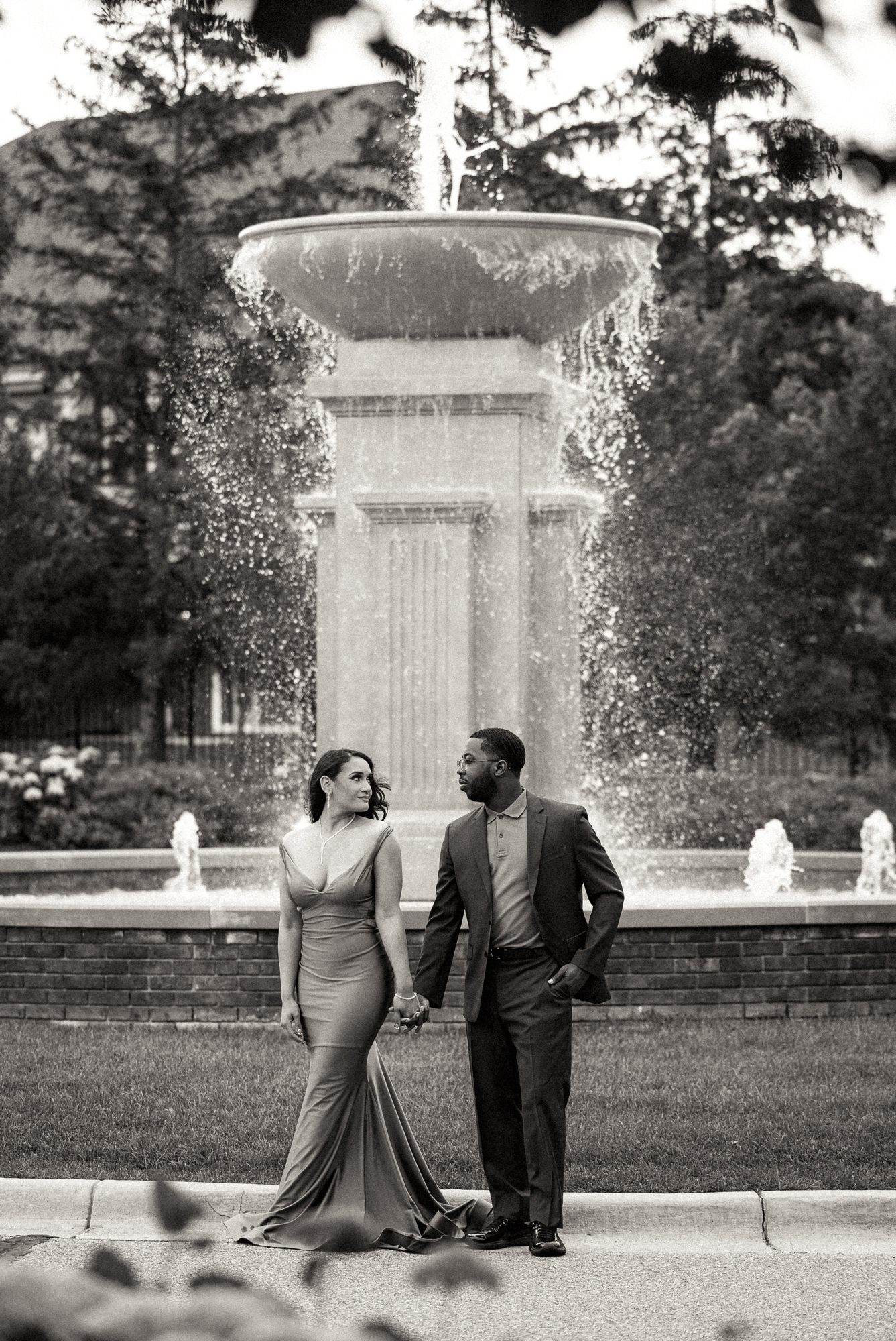 man and woman walking in front of fountain