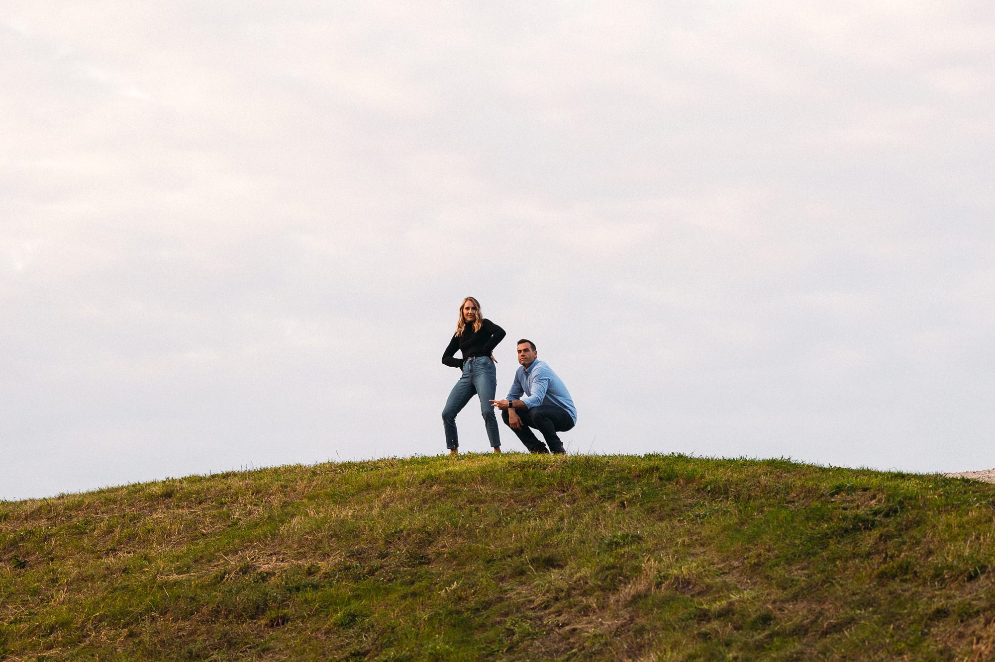 couple acting silly on top of a hill