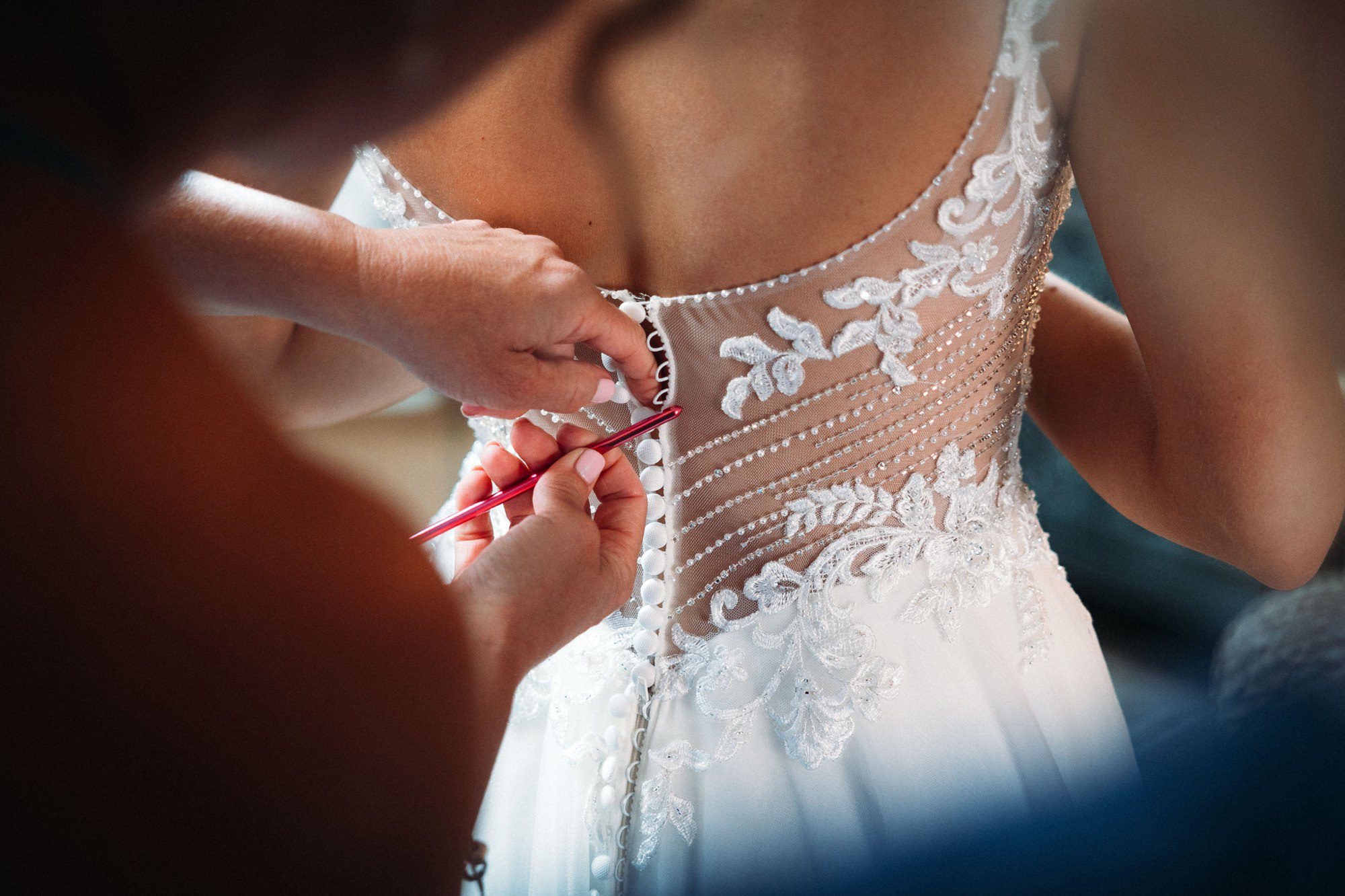 woman buttoning up wedding dress