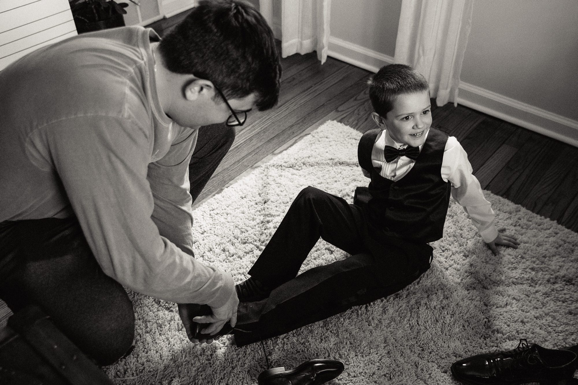 groom tying a boys shoe