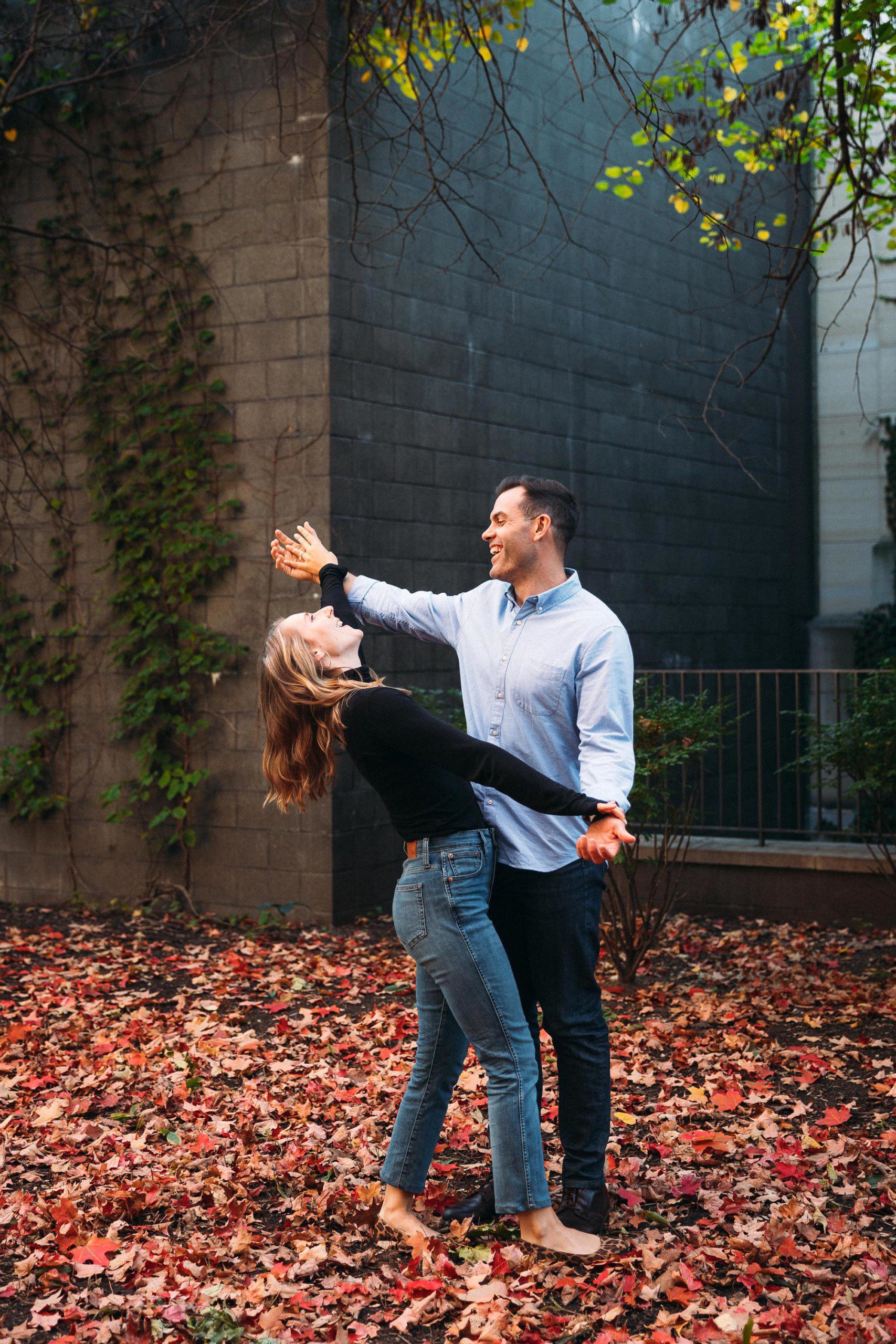 couple playing in the fall leafs