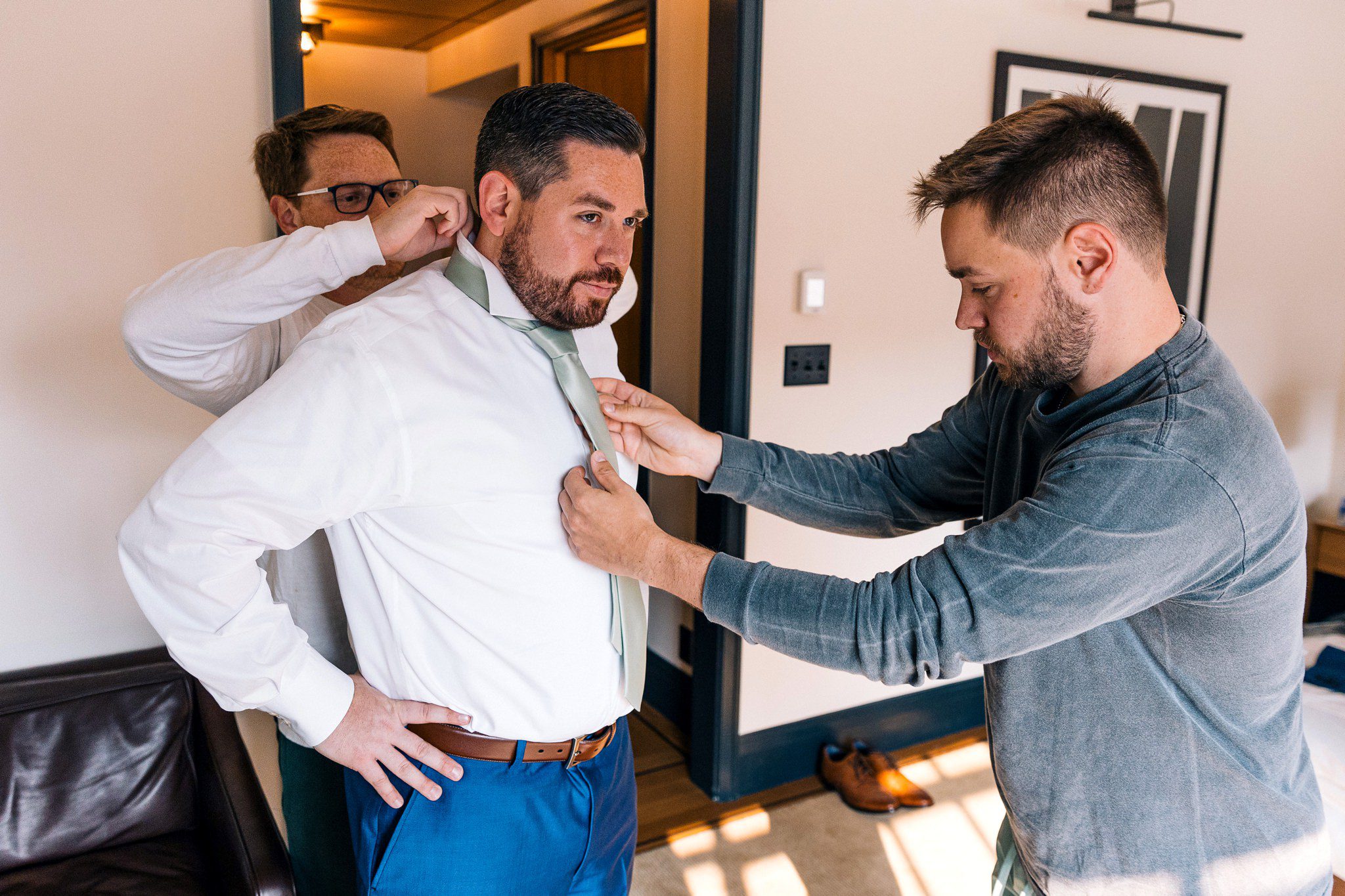 groomsmen helping groom getting ready