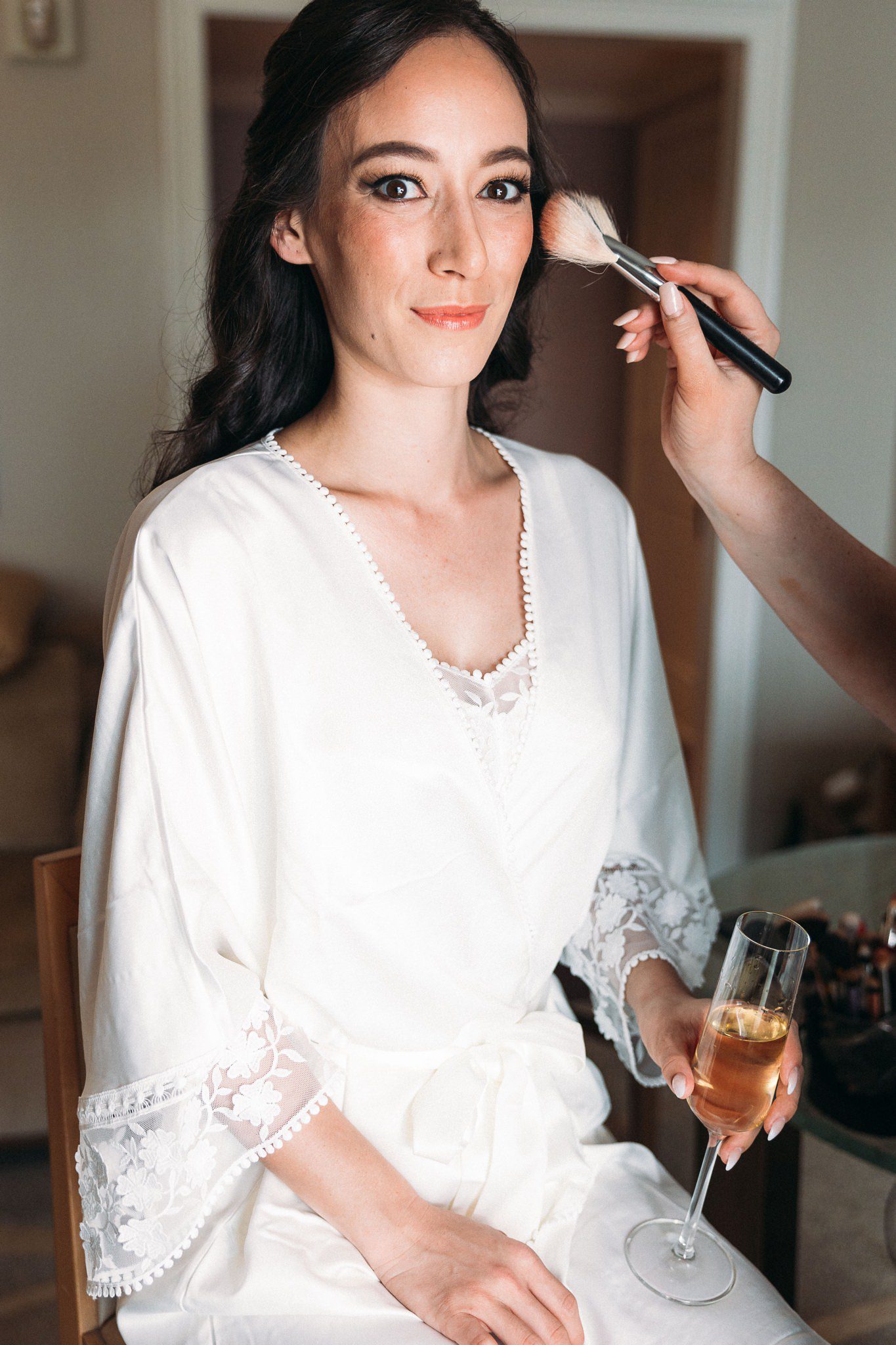 makeup being applied to bride's face