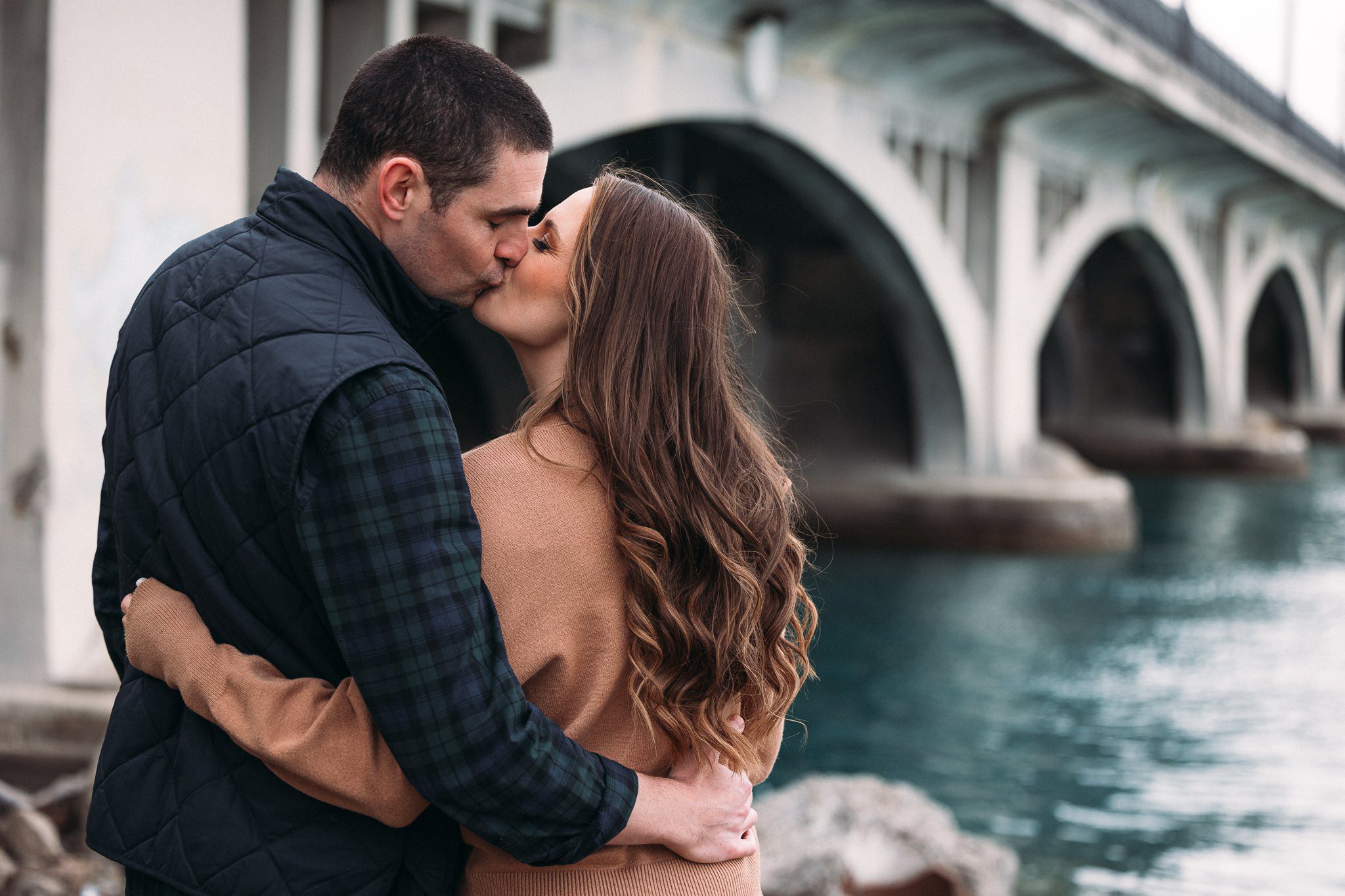Man and woman kissing by bridge
