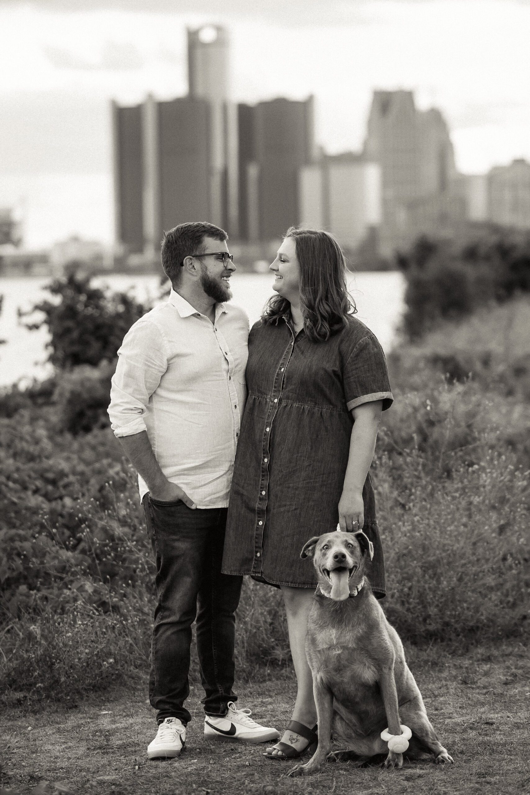 Engaged couple overlooking the Detroit skyline during a riverfront engagement session