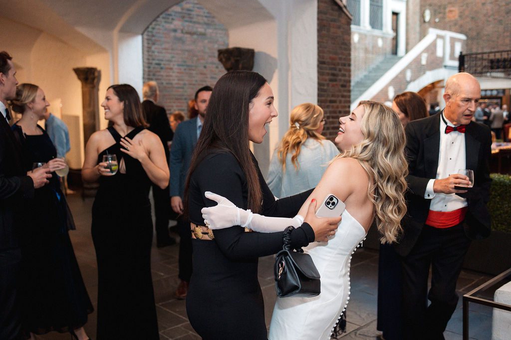 Bride Embracing Guest and Laughing During DIA Wedding