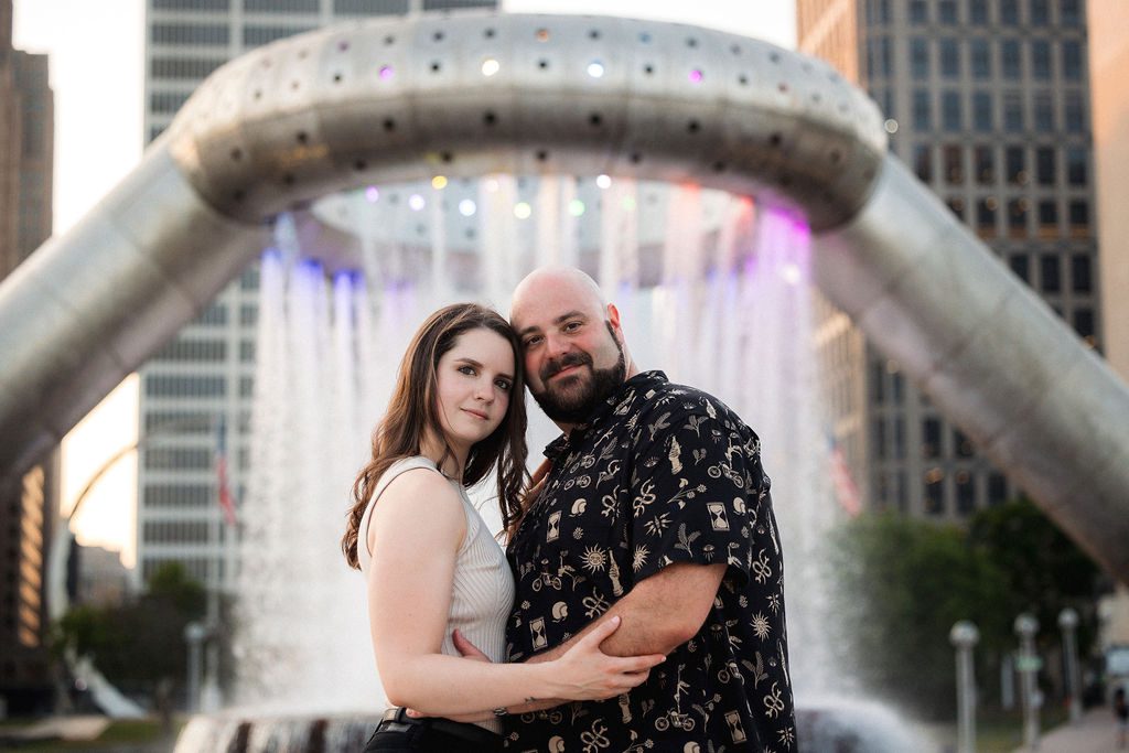 Couple Stand in Front of Fountain in Downtown Detroit for Engagement Photography